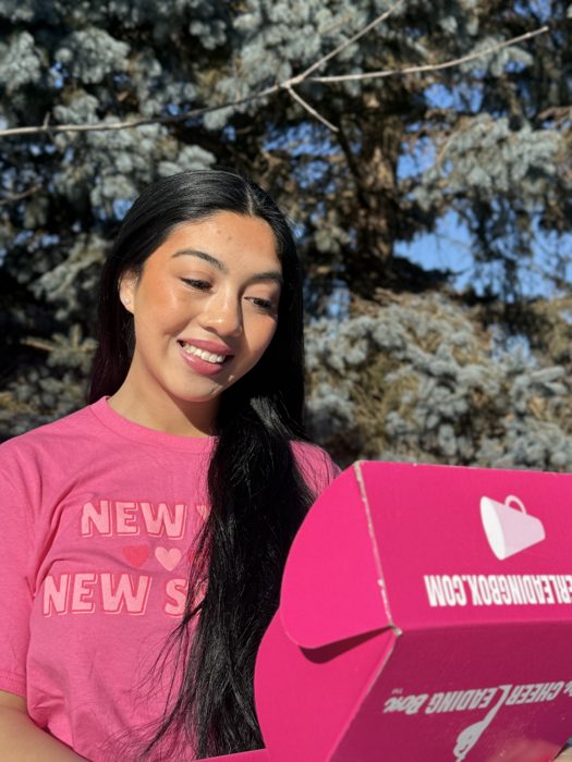 Jazlyn holding her MyCheerleadingBox outside